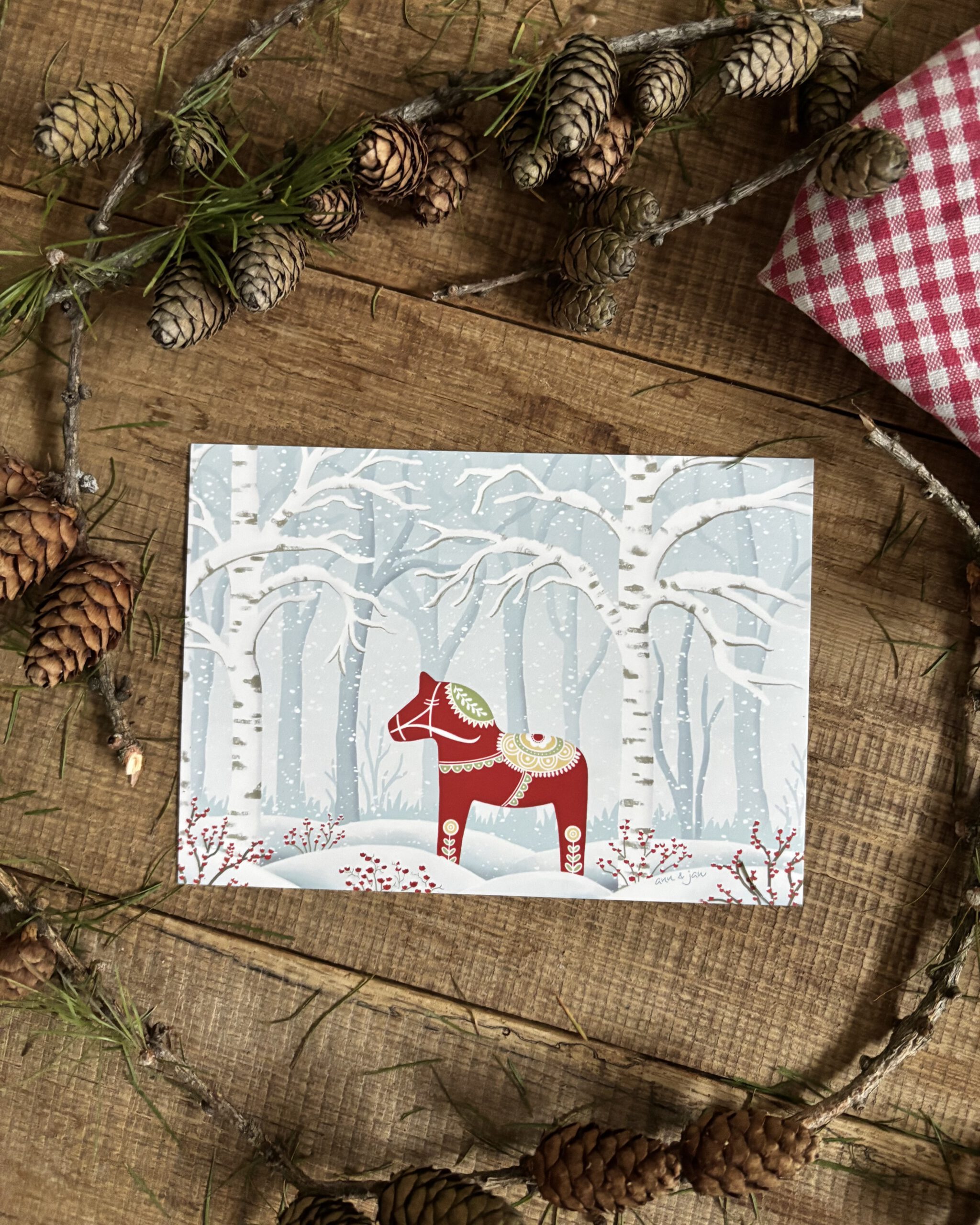Handillustrierte Postkarte God Jul rotes Dalapferd tief verschneiter Winterwald von Ann und Jan