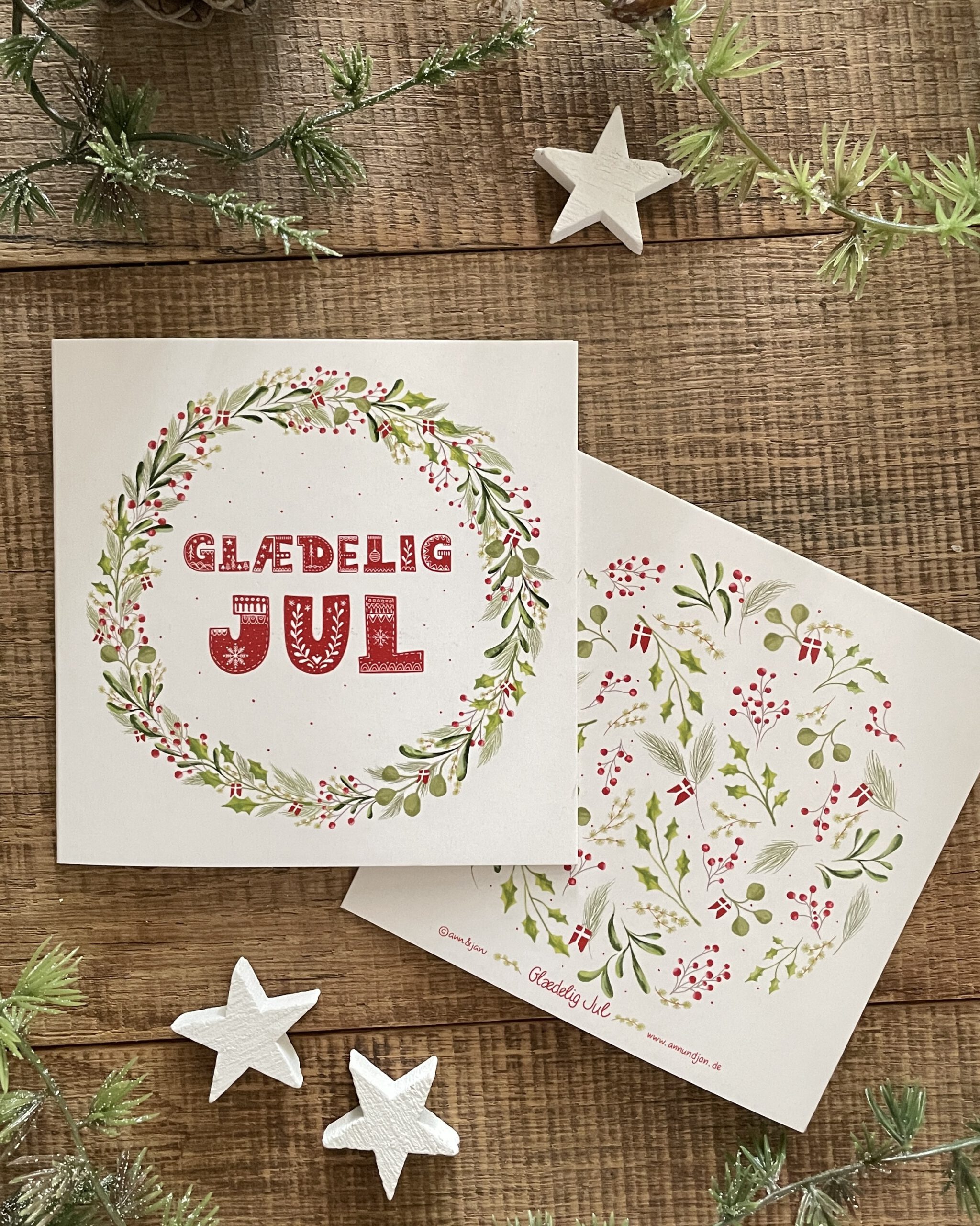 Handillustrierte quadratische Weihnachtsklappkarte Glædelig Jul Kranz grüne Blätter rote Beeren dänisch von Ann und Jan
