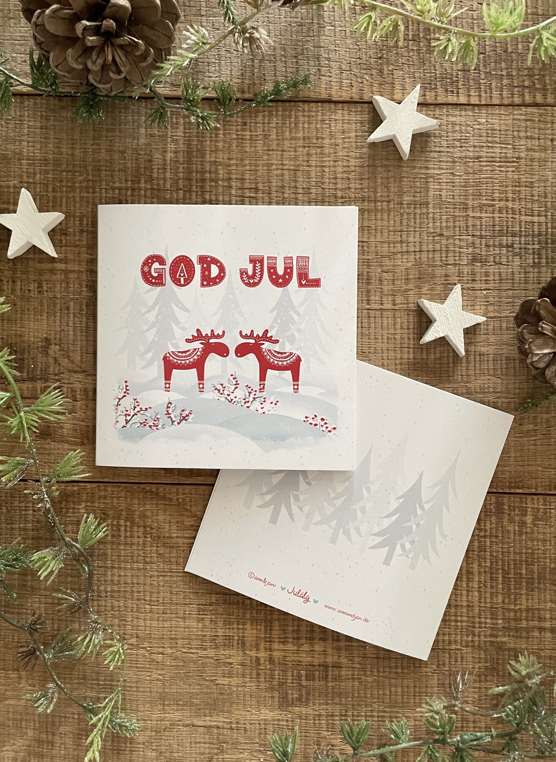 Handillustrierte quadratische Weihnachtsklappkarte Julälg zwei rote Elche Schnee God Jul von Ann und Jan
