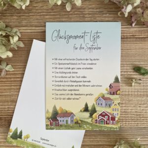 Handillustrierte große Postkarte Glücksmomente September bunte Holzhäuser Hügellandschaft buntes Laub Wiesenblumen von Ann und Jan