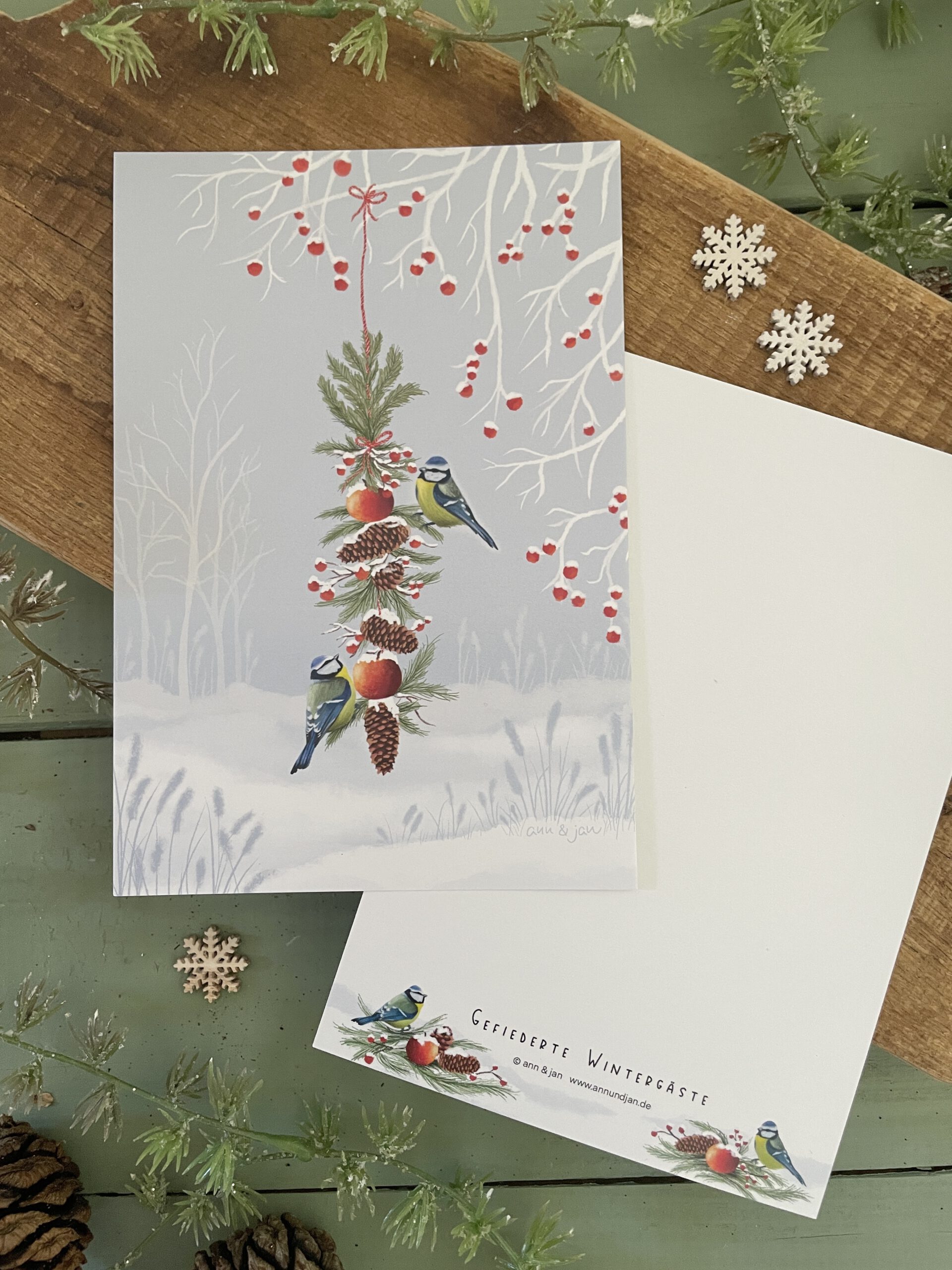 Handillustrierte große Postkarte Gefiederte Wintergäste Blaumeisen Futtergirlande Tannenzapfen Winterlandschaft von Ann und Jan
