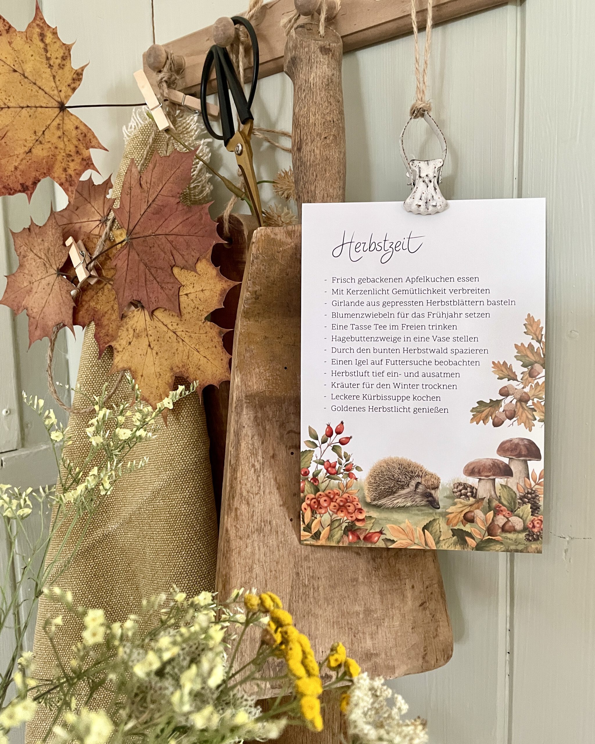 Große Postkarte Herbstzeit mit Herbstmomenten, Igel im Herbstlaub. Vorderseite. Aufgehängt als Deko.